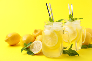 Photo of Freshly made natural lemonade on yellow background. Summer refreshing drink