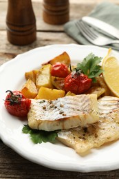 Photo of Tasty cod cooked with vegetables served on wooden table, closeup
