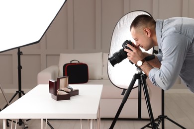 Photo of Professional photographer taking picture of expensive wristwatches in studio