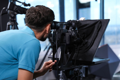 Photo of Professional video camera operator working in studio