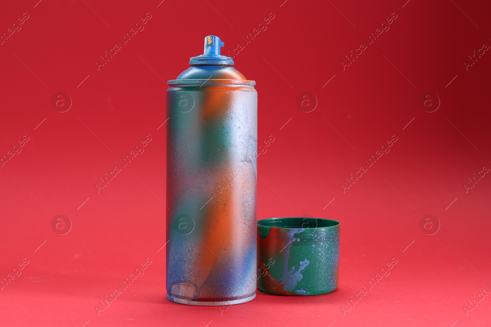 Photo of One can of bright spray paint with cap on red background