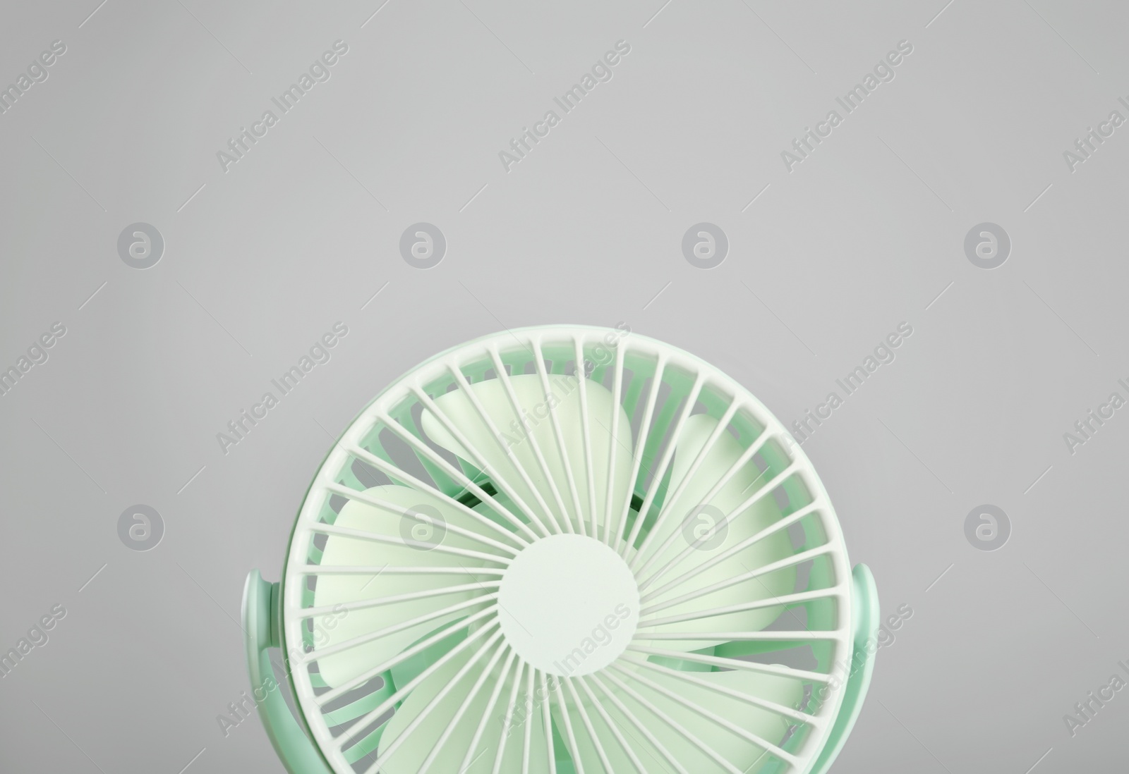 Photo of Portable fan against light grey background. Summer heat