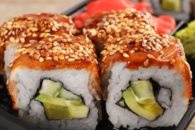 Photo of Box with tasty sushi rolls, closeup. Food delivery service