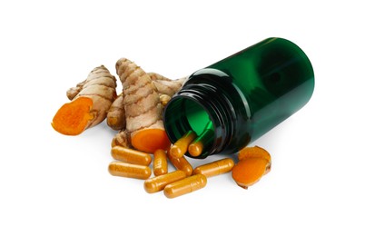 Photo of Bottle with pills and aromatic turmeric roots isolated on white