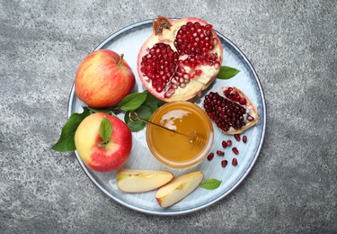 Photo of Honey, pomegranate and apples on grey table, top view. Rosh Hashana holiday