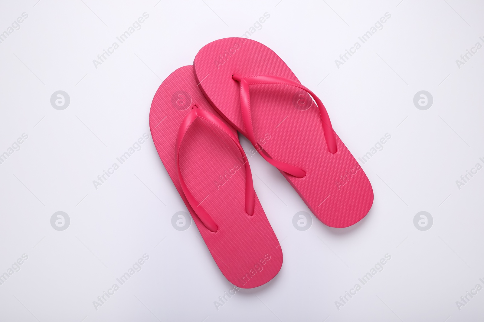 Photo of Stylish pink flip flops on white background, top view