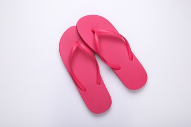 Stylish pink flip flops on white background, top view