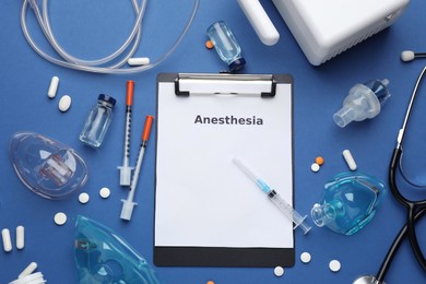 Flat lay composition of clipboard with word Anesthesia and drugs on blue background