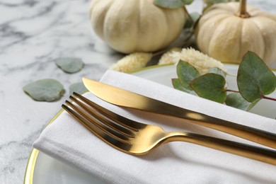 Photo of Festive table setting with autumn decor on white marble background, closeup