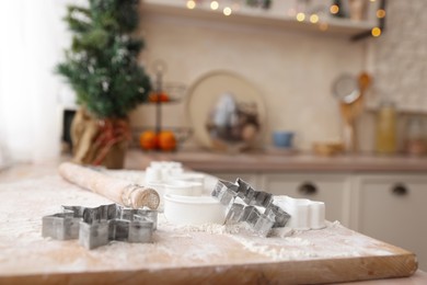 Photo of Cookie cutters on wooden table in kitchen, space for text