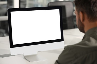 Photo of Man using modern computer at white desk in office, back view. Mockup for design