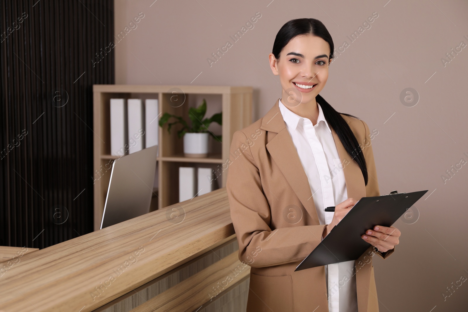 Photo of Receptionist with clipboard near countertop in office, space for text