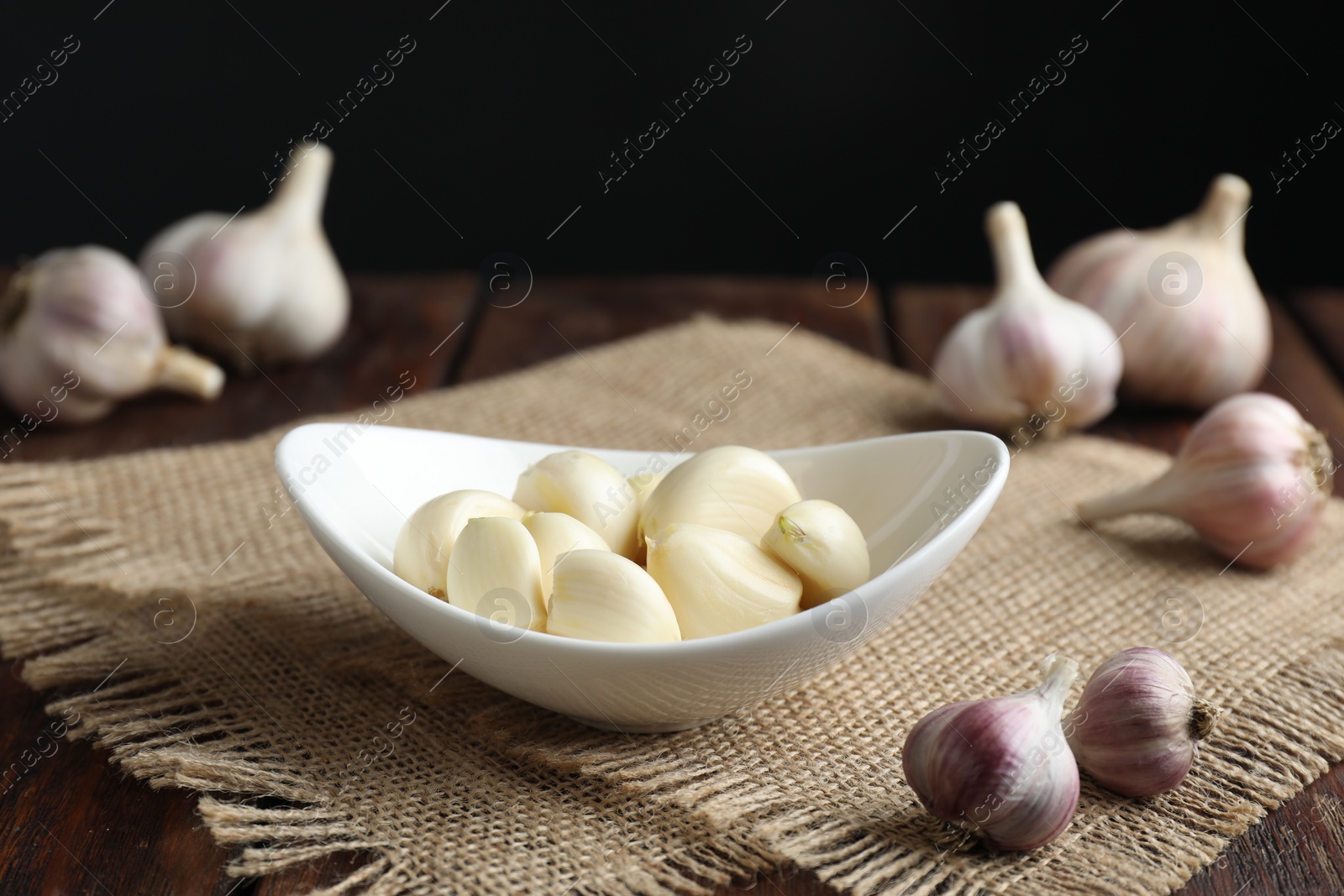 Photo of Fresh garlic cloves and bulbs on wooden table