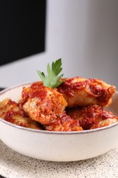 Photo of Delicious stuffed cabbage rolls cooked with tomato sauce in bowl, closeup. Space for text