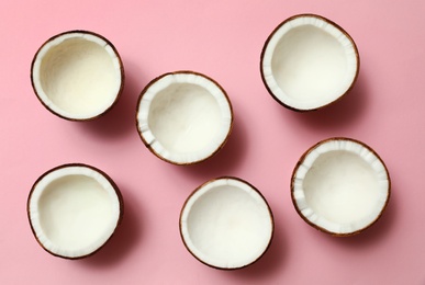 Photo of Fresh coconut halves on pink background, flat lay
