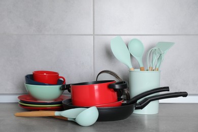 Set of cooking utensils and cookware on grey countertop