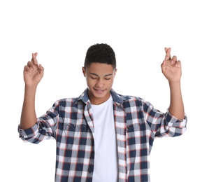 Photo of African-American teenage boy crossing his fingers on white background