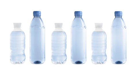 Row of different plastic bottles with water on white background