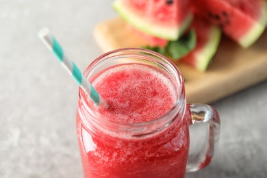 Photo of Tasty summer watermelon drink in mason jar on table, closeup