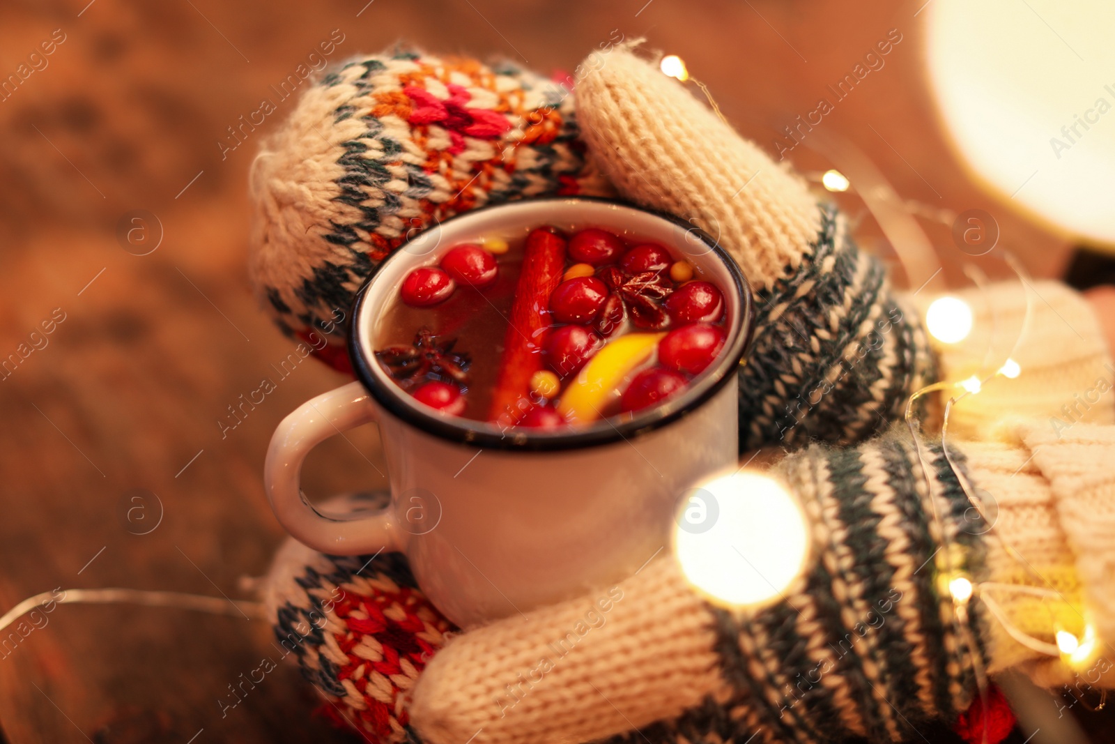 Photo of Woman with mulled wine at wooden table, closeup