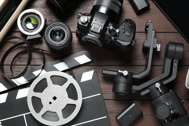 Photo of Flat lay composition with camera and video production equipment on brown wooden background