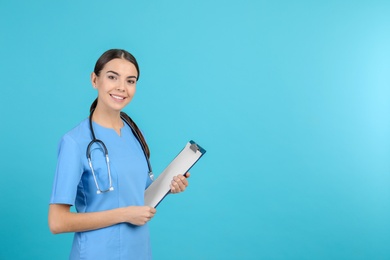 Photo of Portrait of medical assistant with stethoscope and clipboard on color background. Space for text