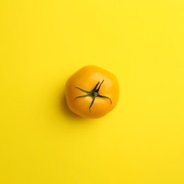 Photo of Yellow tomato on color background, top view