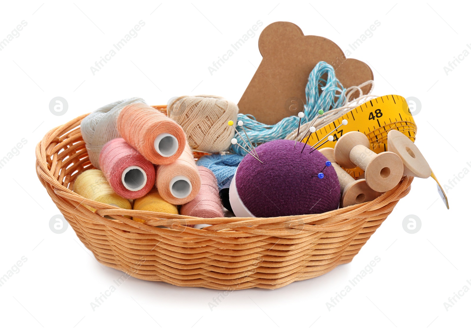 Photo of Basket with set of color sewing threads on white background