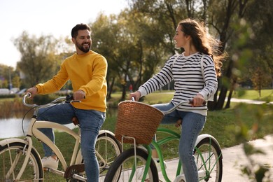 Photo of Beautiful young couple riding bicycles in park