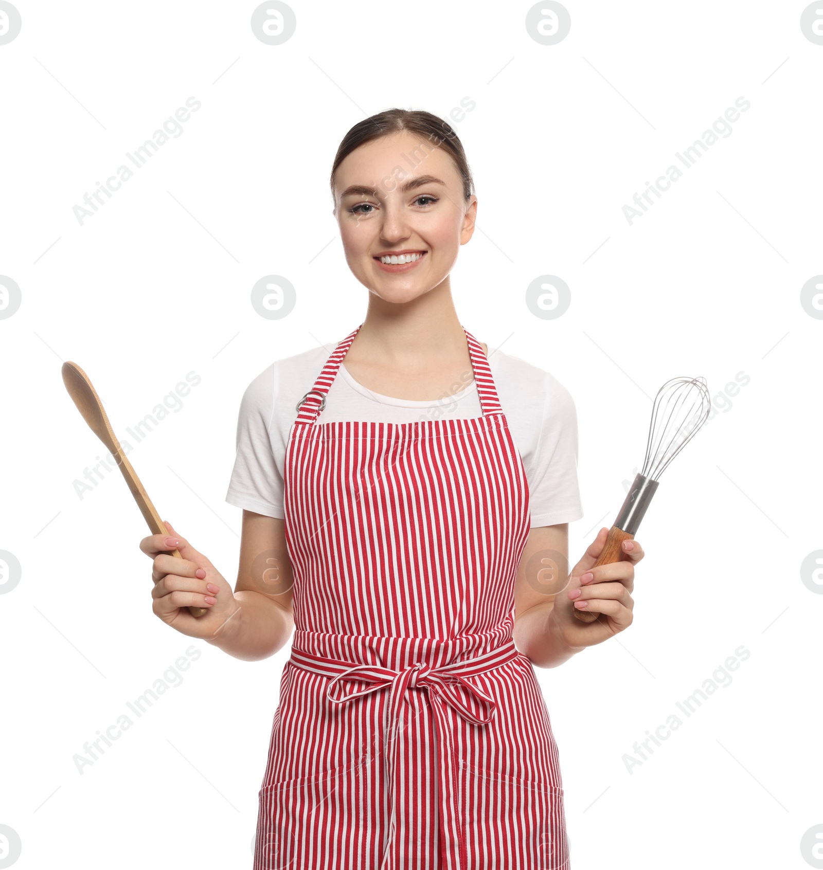 Photo of Beautiful young woman in striped apron with kitchen tools on white background