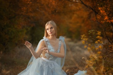 Photo of Beautiful girl wearing fairy dress in autumn forest