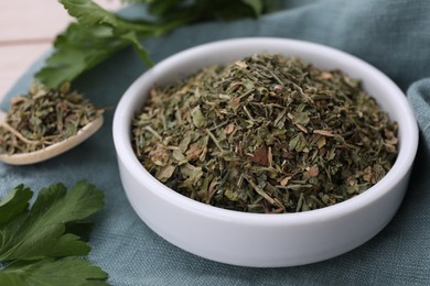 Photo of Dried aromatic parsley and fresh leaves on table, closeup