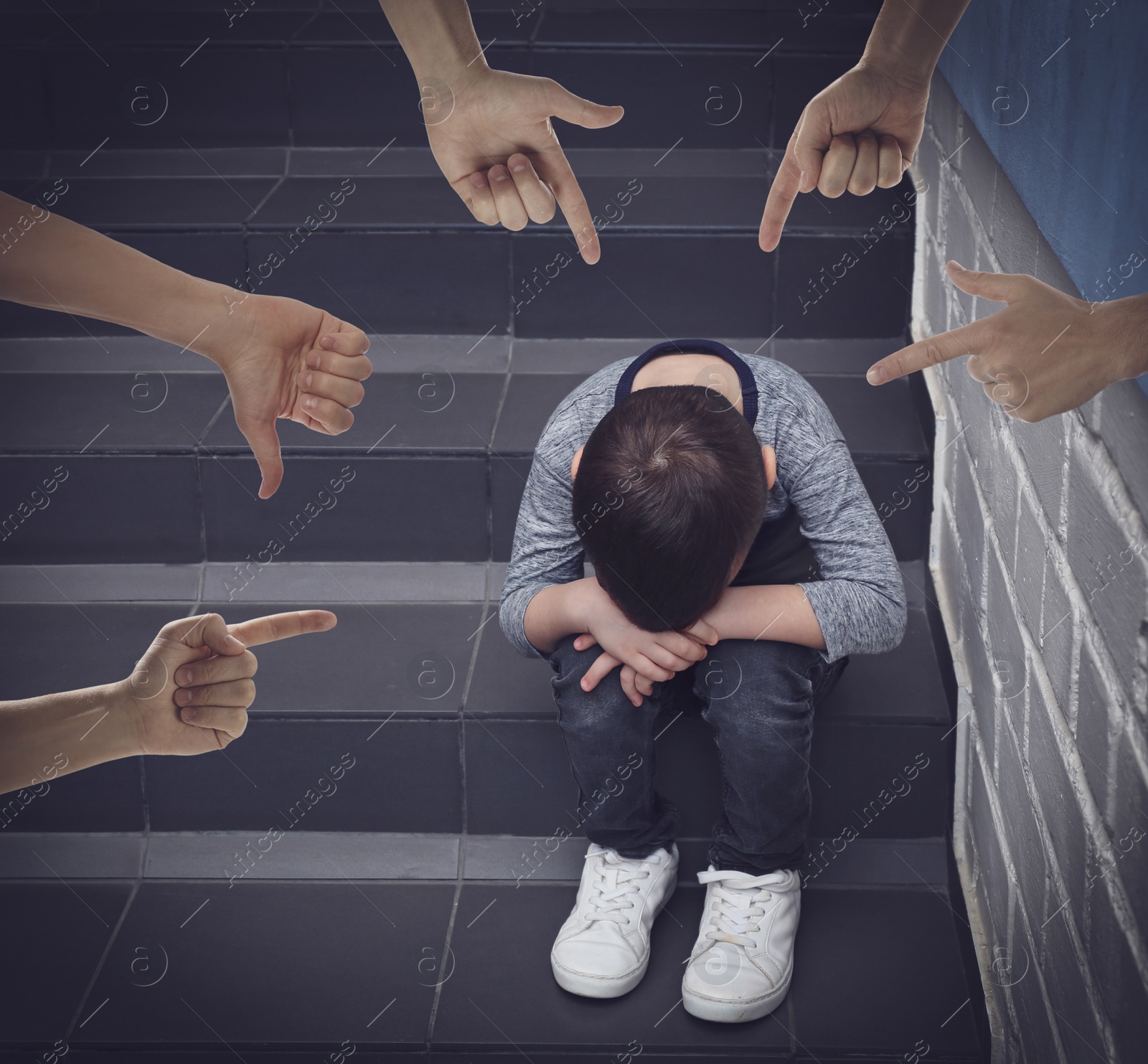 Image of People bullying little boy on stairs indoors