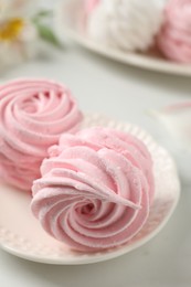 Photo of Plate with delicious pink zephyrs on white table, closeup