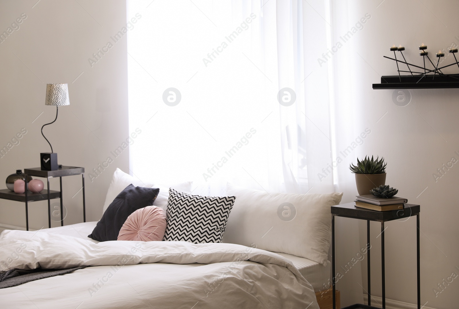 Photo of Large comfortable bed in stylish room interior