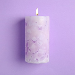 Alight scented wax candle on color background