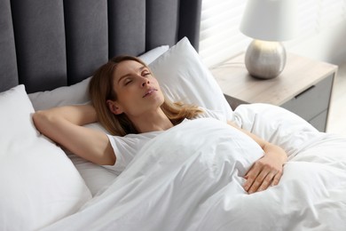 Photo of Woman snoring while sleeping in bed at home