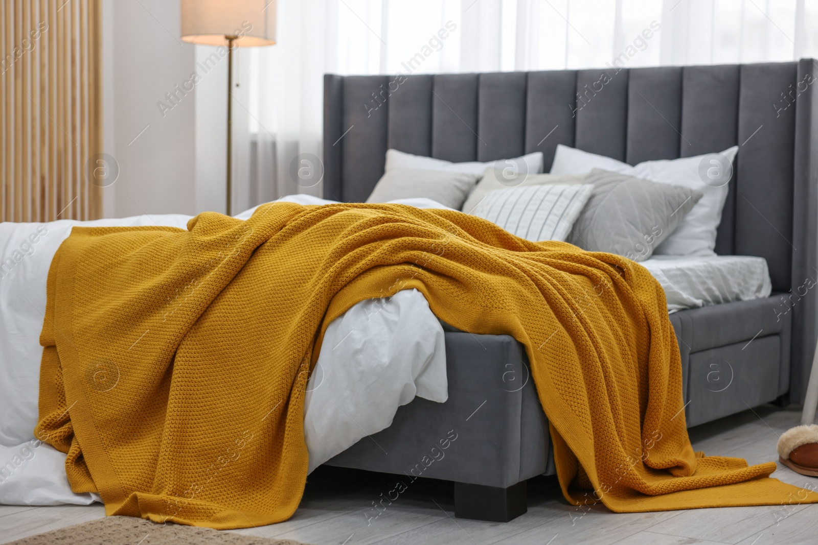 Photo of Bright plaid on bed in stylish bedroom