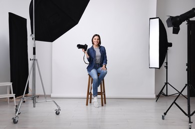 Photo of Professional photographer with camera in modern photo studio