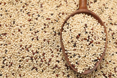 Photo of Heap of raw quinoa seeds and spoon, top view. Space for text