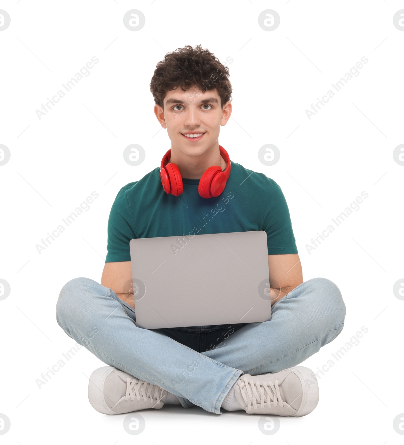 Photo of Portrait of student with laptop and headphones sitting on white background