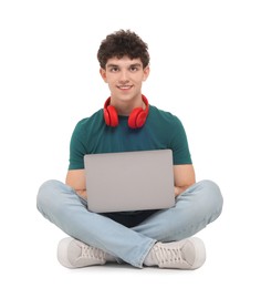 Photo of Portrait of student with laptop and headphones sitting on white background