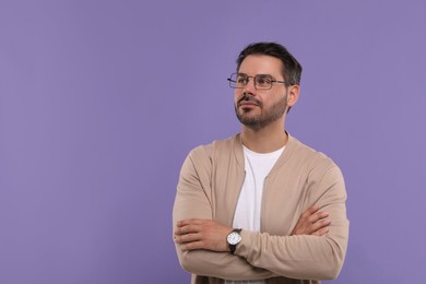 Portrait of man in stylish glasses on violet background, space for text