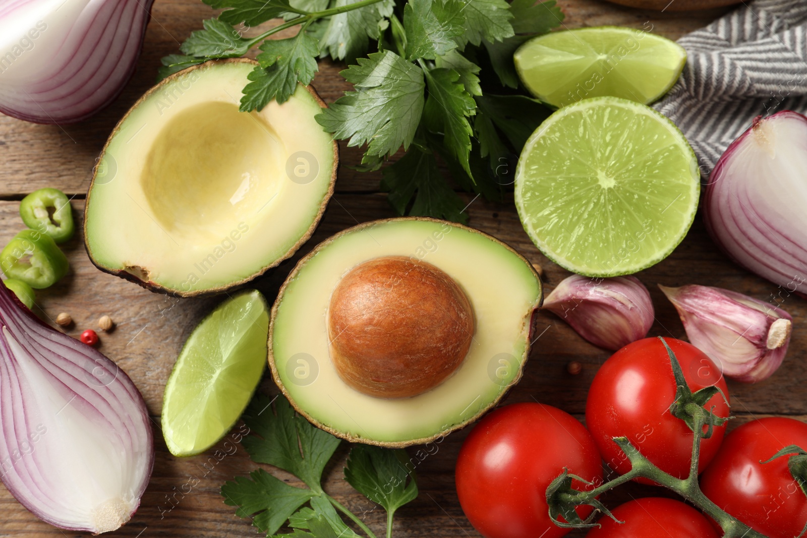 Photo of Fresh ingredients for guacamole on wooden table, flat lay