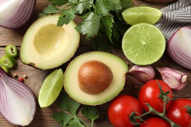 Fresh ingredients for guacamole on wooden table, flat lay