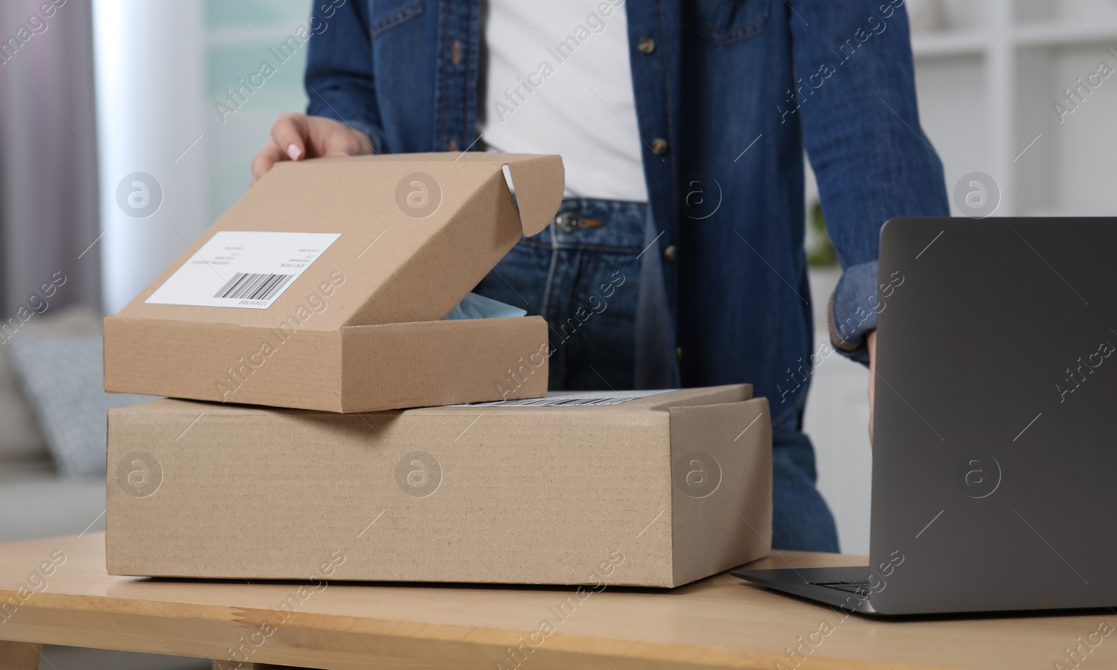 Photo of Woman unpacking parcel at home, closeup. Online store