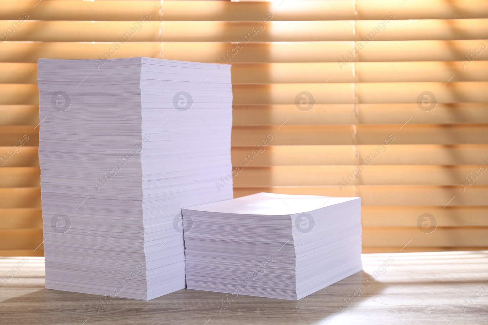 Photo of Stacks of paper sheets on wooden table