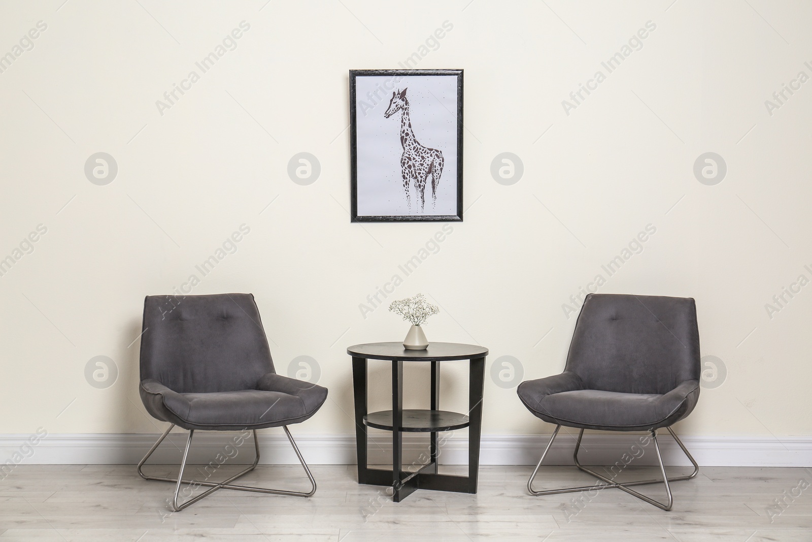 Photo of Room interior with modern chairs and table near light wall