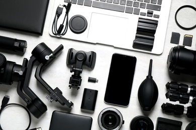 Photo of Camera equipment and accessories for video production on light background, flat lay