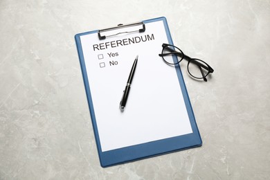 Photo of Referendum ballot with clipboard, glasses and pen on light grey marble table, flat lay